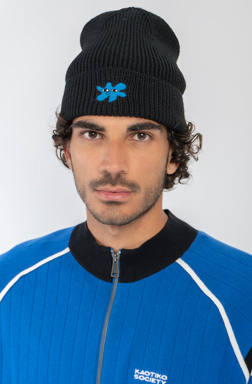 Gorro de punto negro Kaotiko Breeze Black con vuelta ancha y bordado azul de una figura con ojos.