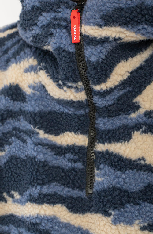 Polar Après Ski Ivory de tejido fleece con estampado abstracto azul marino, azul y marfil, capucha y media cremallera.