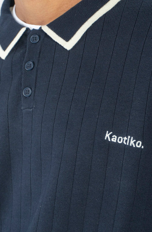 Polo unisex de punto azul marino de canalé con cuello de botones, detalles en contraste color crudo y bordado Kaotiko en el pecho.