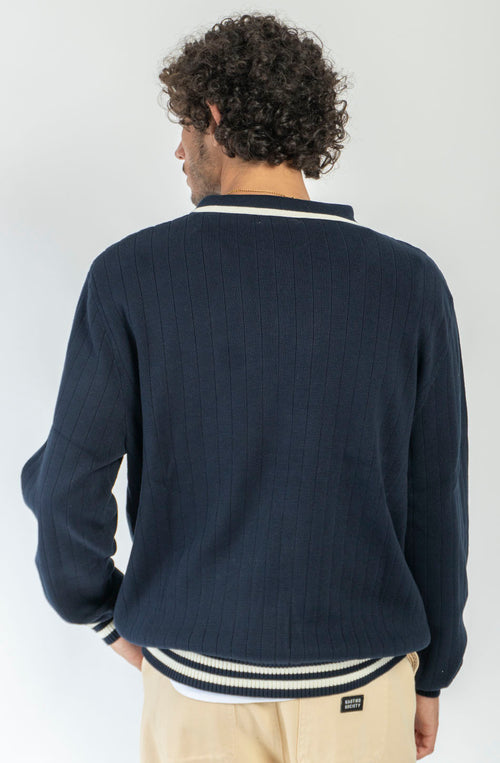 Polo unisex de punto azul marino de canalé con cuello de botones, detalles en contraste color crudo y bordado Kaotiko en el pecho.