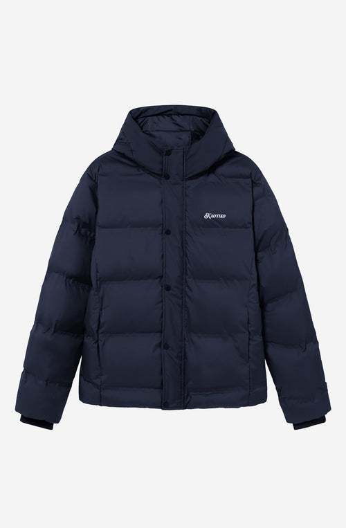 Chaqueta acolchada azul marino oscuro con capucha, cierre frontal y logo Kaotiko bordado en el pecho.