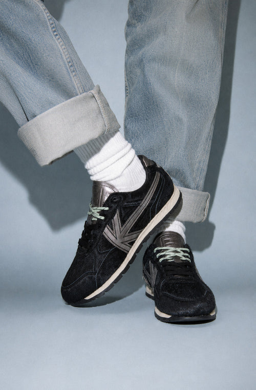 Zapatillas Seattle Pony Black de pelo negro con detalles metalizados en gris y suela de estilo retro.