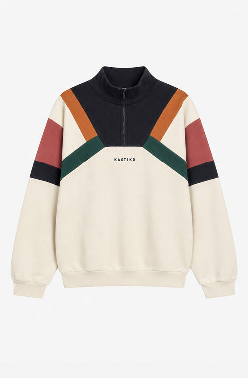 Sudadera unisex Aleck en color crudo con paneles geométricos azul marino, naranja, verde y rosa, cuello alto con media cremallera y logo Kaotiko en el pecho.