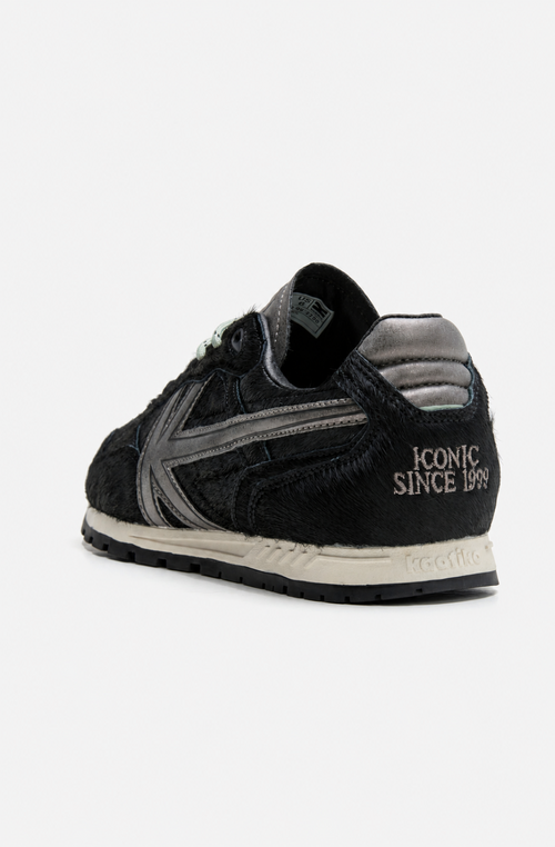Zapatillas Seattle Pony Black de pelo negro con detalles metalizados en gris y suela de estilo retro.