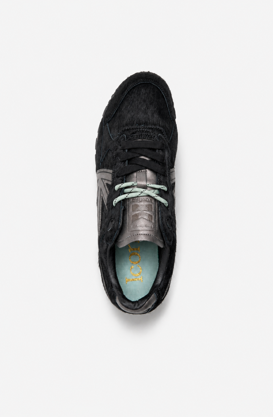 Zapatillas Seattle Pony Black de pelo negro con detalles metalizados en gris y suela de estilo retro.