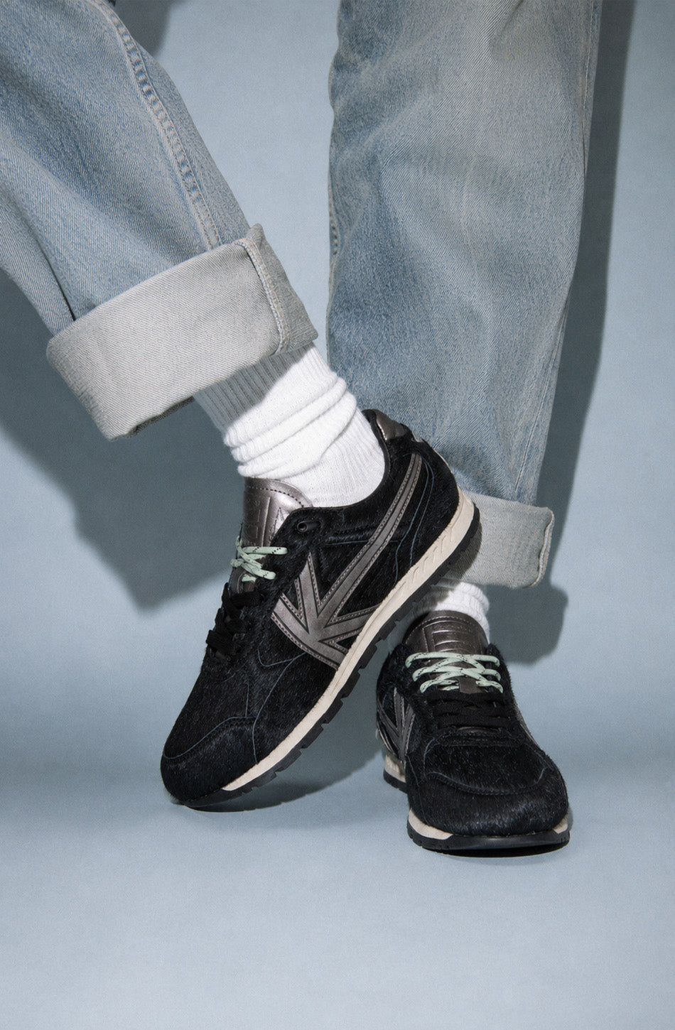 Zapatillas Seattle Pony Black de pelo negro con detalles metalizados en gris y suela de estilo retro.