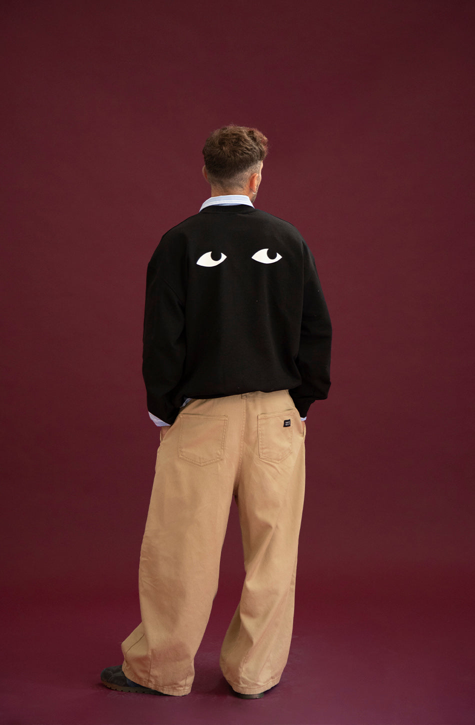 Jersey oversize unisex negro con gráfico de ojos en la espalda.